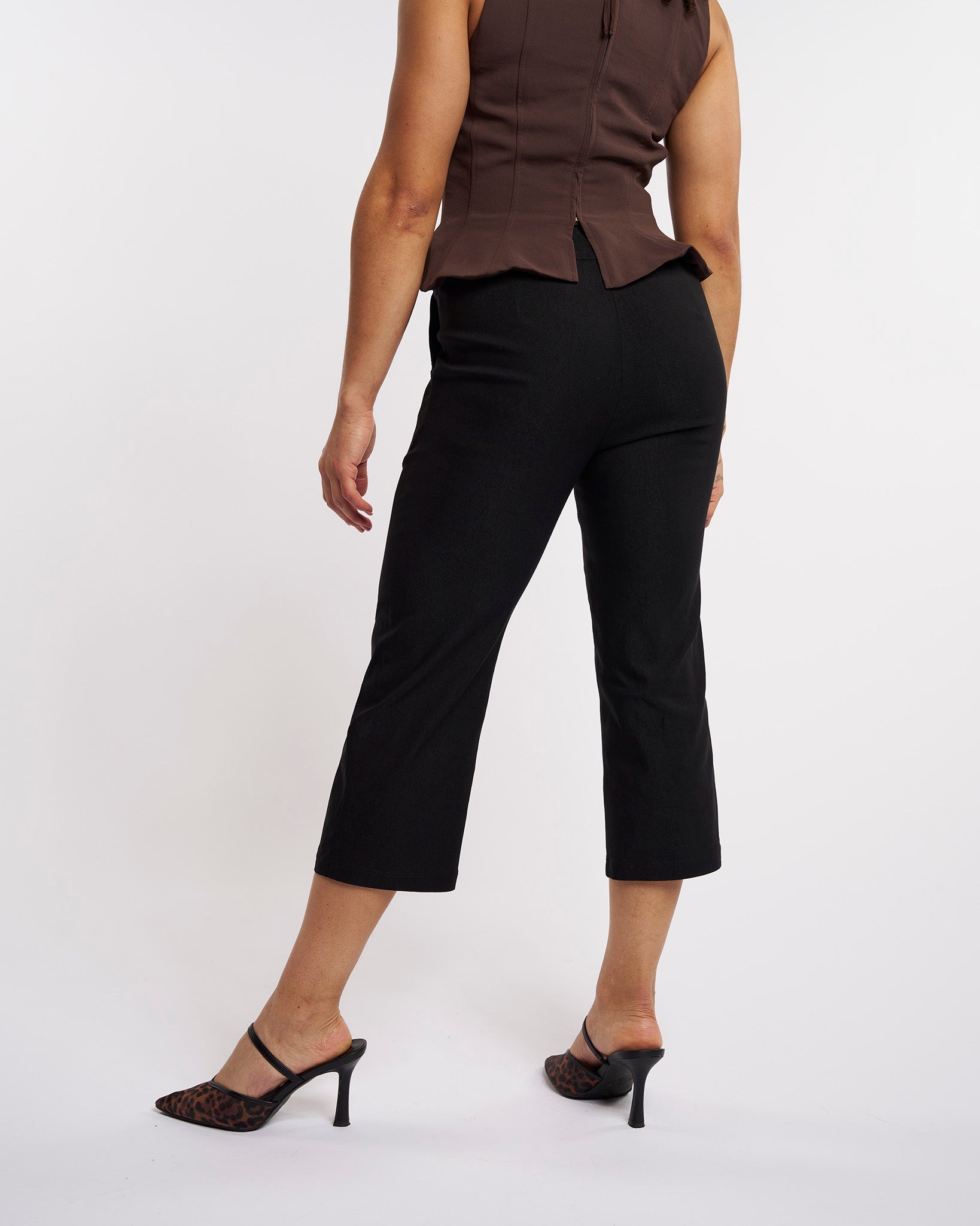 Back view of black high-rise stretch capri pants for women with a fitted straight-leg silhouette.