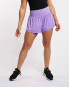 Front view of lavender high-waisted athletic shorts with a flowy skort-style outer layer and built-in shorts.