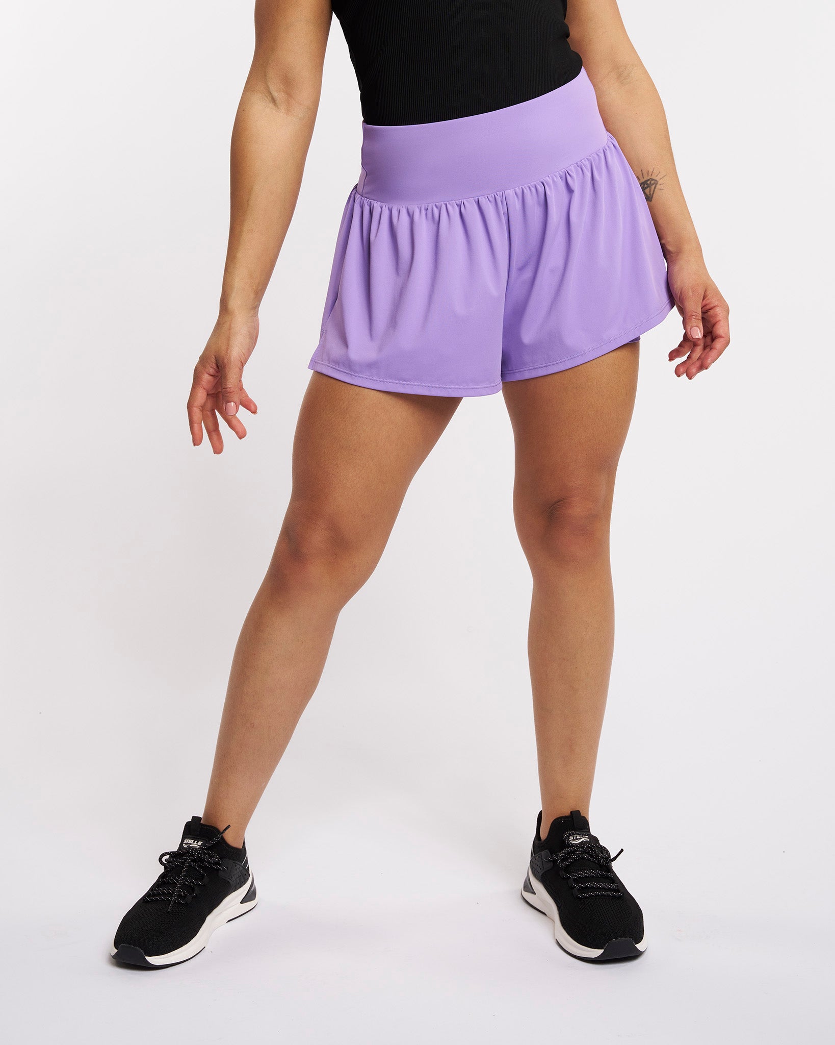 Front view of lavender high-waisted athletic shorts with a flowy skort-style outer layer and built-in shorts.