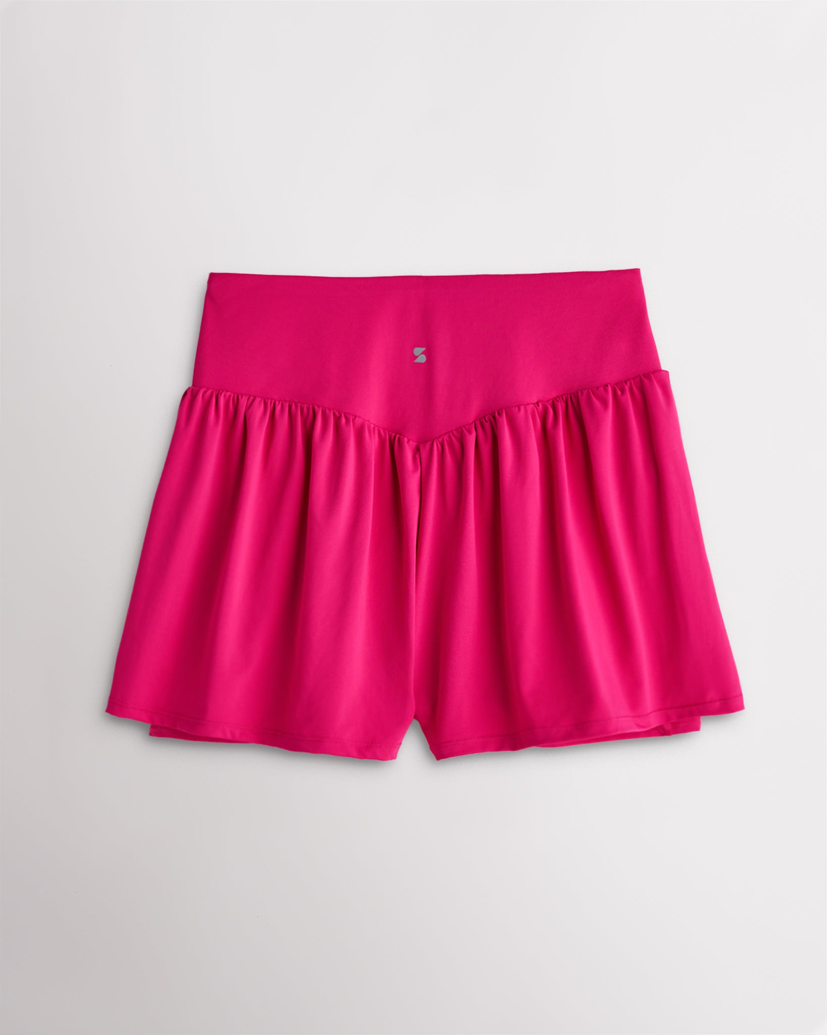 Back view of women’s dreamhouse pink high waisted athletic shorts with a flowy layered design and V-contour back seam.