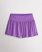 Women’s lavender 2-in-1 high waisted athletic shorts with a flowy outer layer, built-in shorts, and side slit detail.