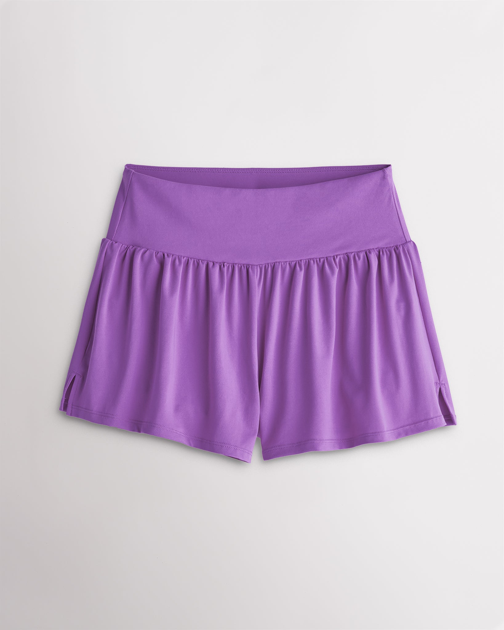 Women’s lavender 2-in-1 high waisted athletic shorts with a flowy outer layer, built-in shorts, and side slit detail.