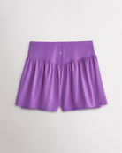 Back view of women’s lavender high waisted athletic shorts with a flowy layered design and V-contour back seam.