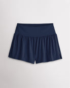 Women’s navy 2-in-1 high waisted athletic shorts with a flowy outer layer, built-in shorts, and side slit detail.