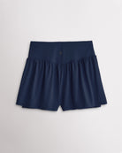 Back view of women’s navy high waisted athletic shorts with a flowy layered design and V-contour back seam.