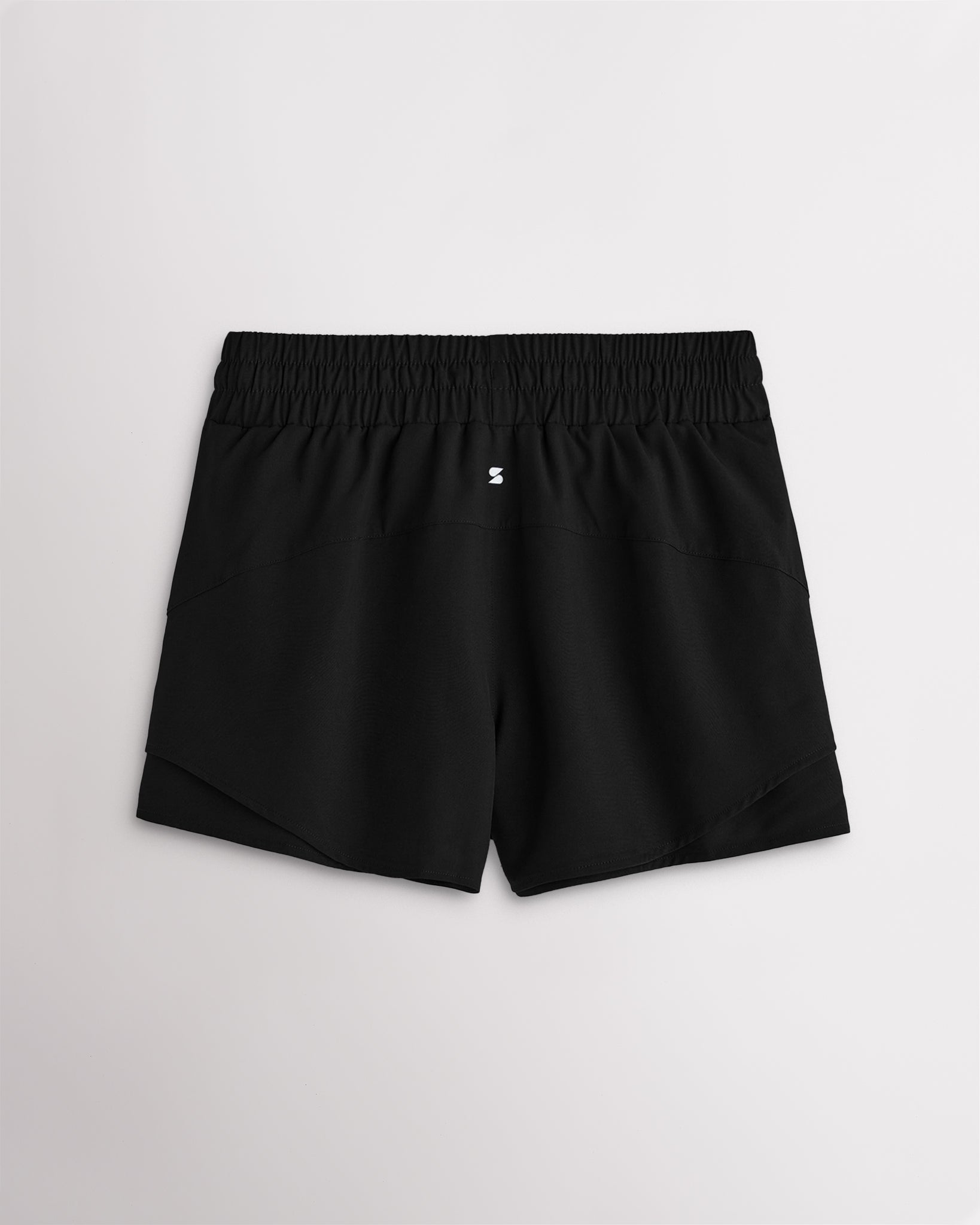 Back view of women’s black running shorts with a high-rise elastic waistband and layered hem design.