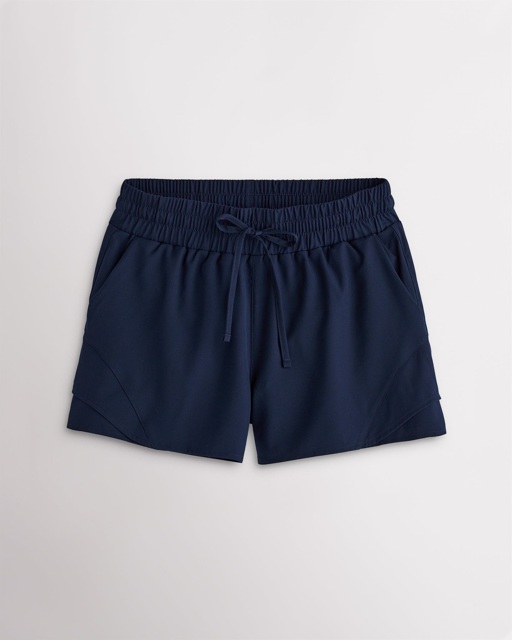 Women’s navy high-rise running shorts with a wide elastic waistband, drawstring tie, side pockets, and double-layer hem.