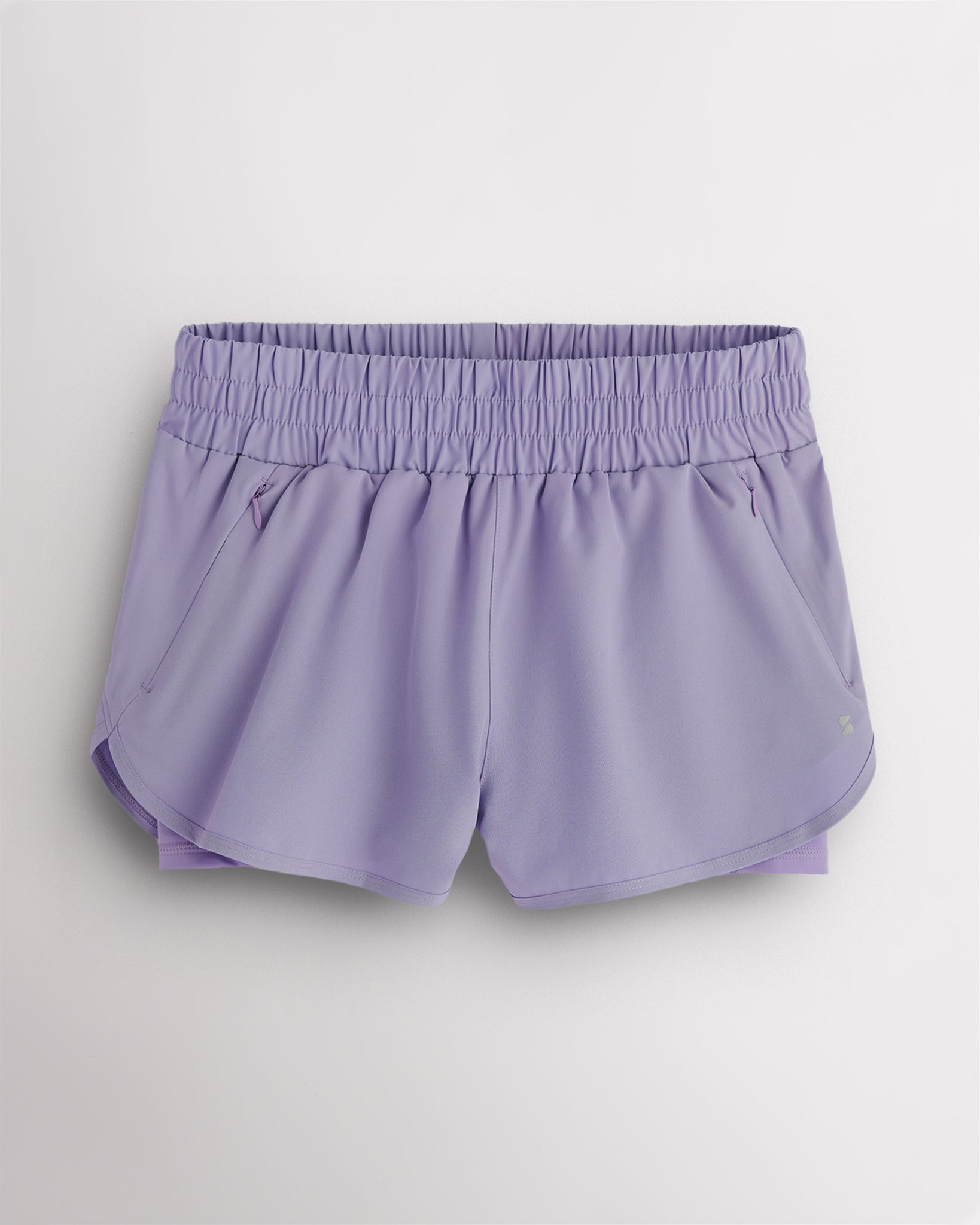 Purple Haze Stelle RushMode 2-in-1 running shorts with wide elastic waistband, zipper pockets, inner shorts lining, and curved dolphin hem.