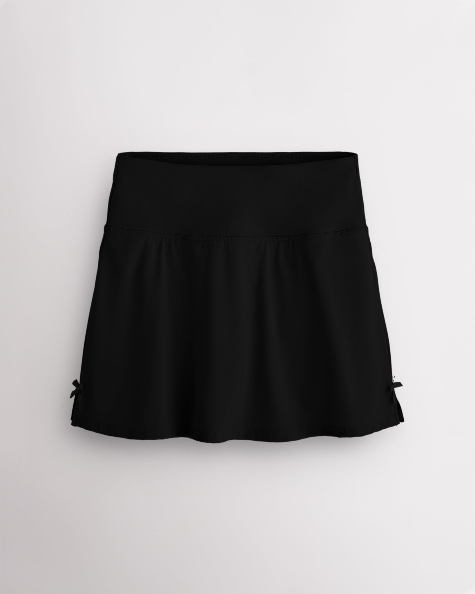 Black Stelle classic tennis skirt with a high-waisted fit, slightly flared silhouette, side slits, and bow ribbon details.