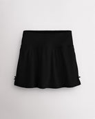 Black Stelle classic tennis skirt with a high-waisted fit, slightly flared silhouette, side slits, and bow ribbon details.