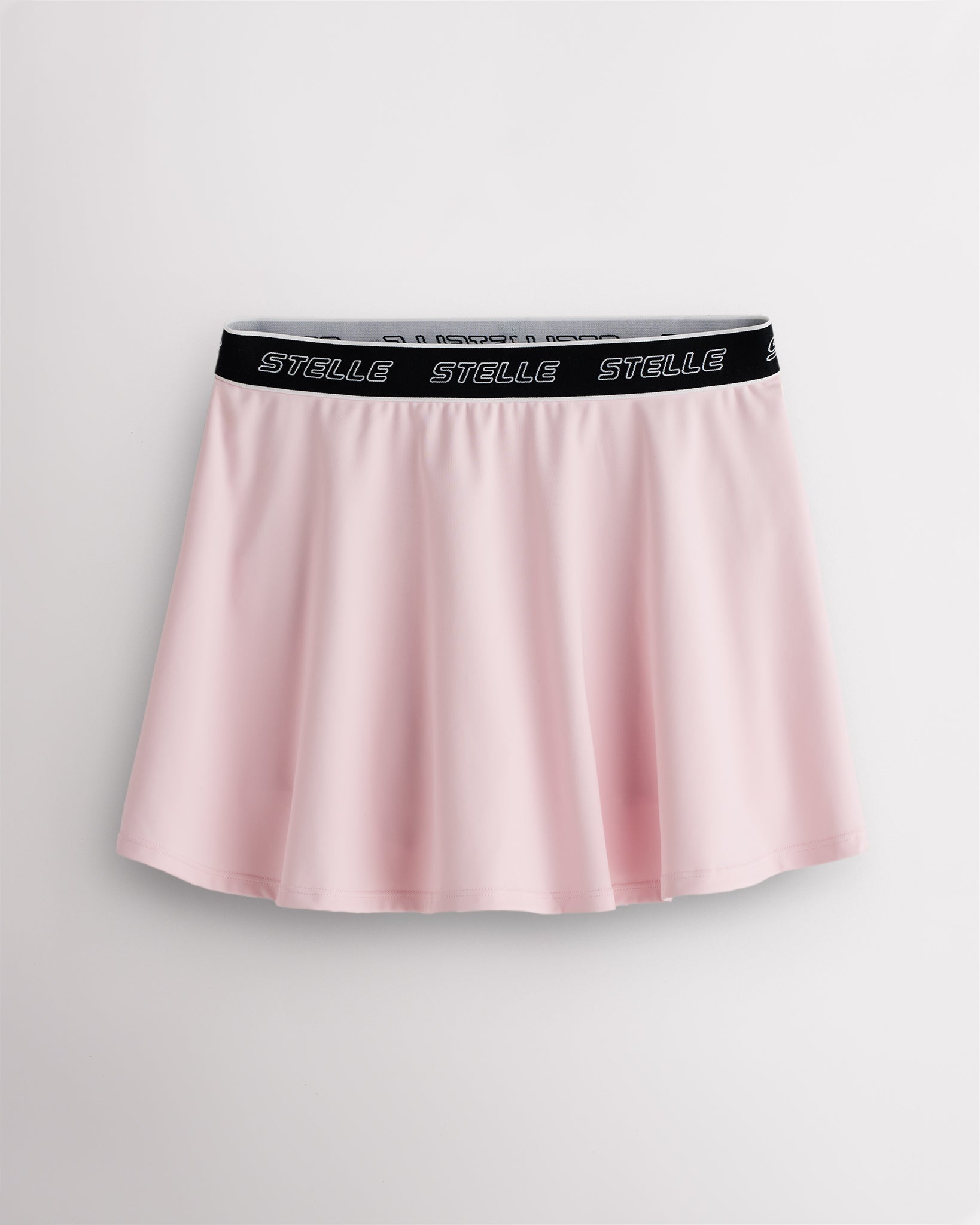 Ballet Pink Stelle tennis skirt with black logo elastic waistband, high-waisted fit, flared skirt, and built-in shorts.