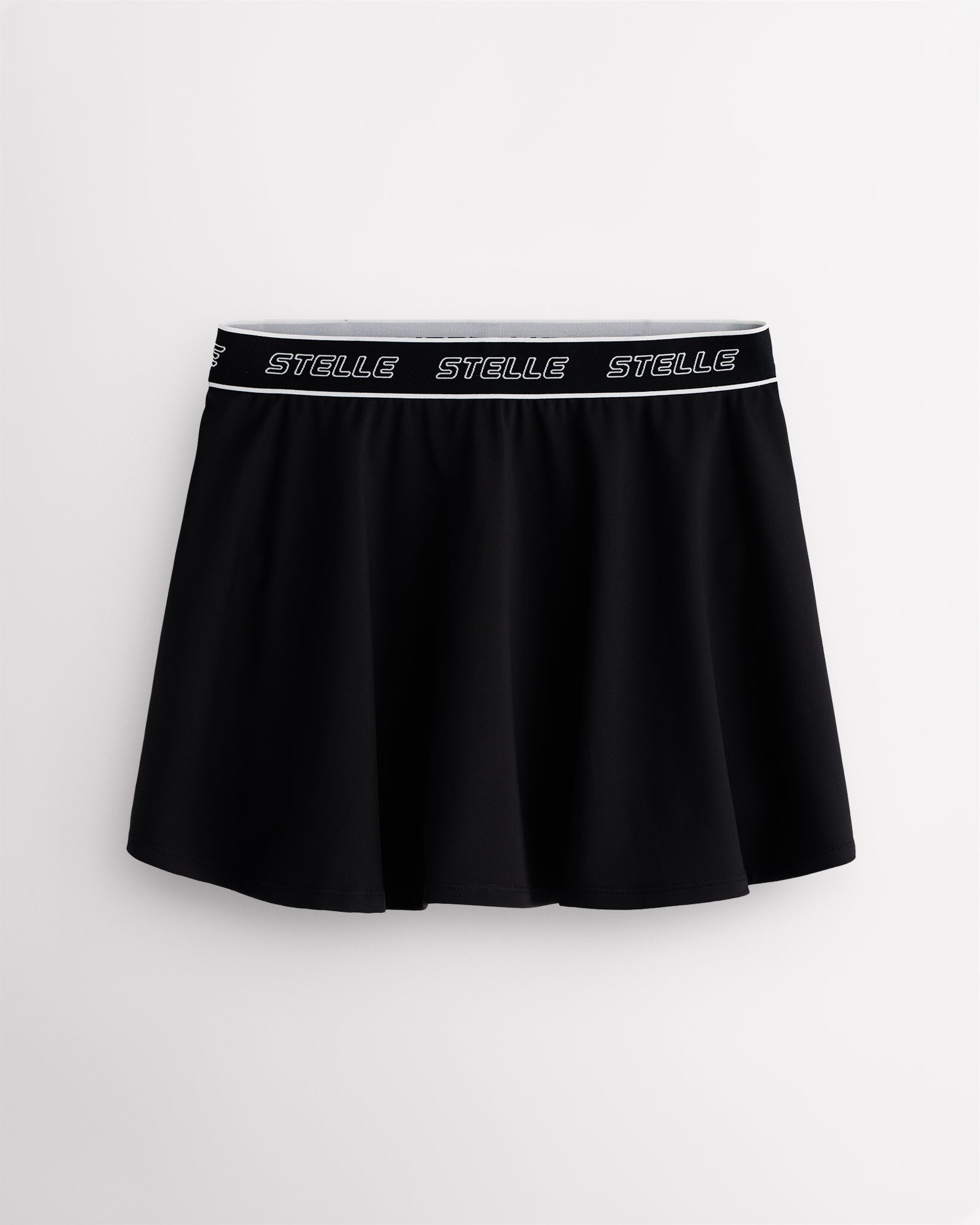 Black Stelle tennis skirt with black logo elastic waistband, high-waisted fit, flared skirt, and built-in shorts.