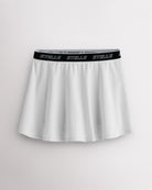 White Stelle tennis skirt with black logo elastic waistband, high-waisted fit, flared skirt, and built-in shorts.