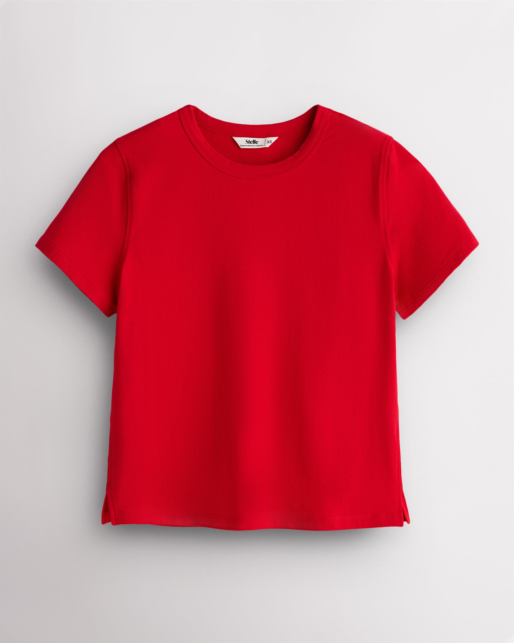 Red Stelle womens short sleeve basic t shirt with crewneck, relaxed boxy fit, and side slits on white background