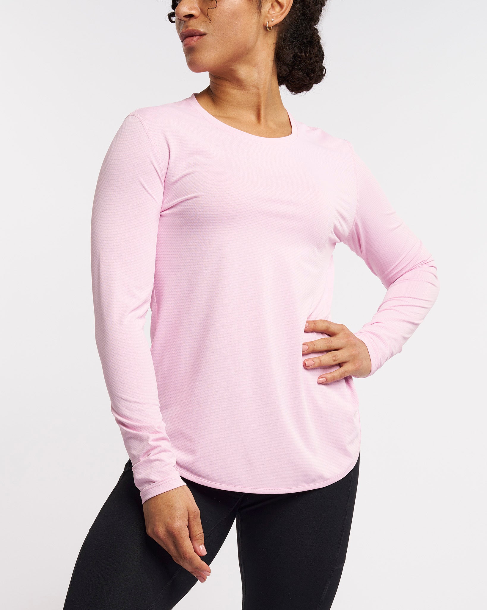 Woman wearing petal pink long sleeve sun protection shirt with UPF 50+, lightweight breathable fabric and curved hem, activewear top.