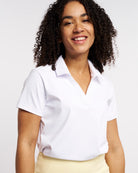 Close-up of white womens polo shirt featuring modern V-neck collar and smooth athletic fabric