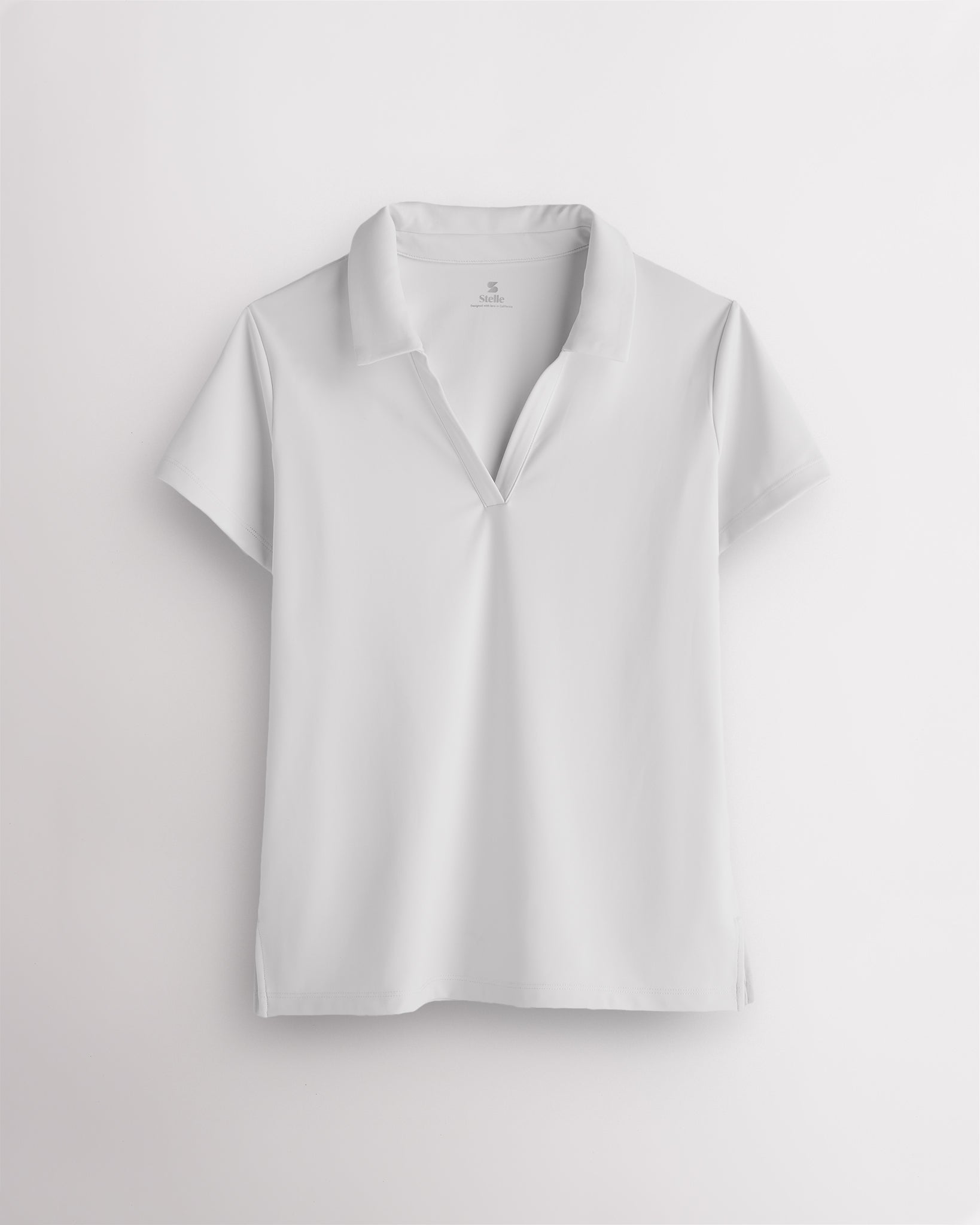 White womens V-neck athletic polo shirt with classic collar, slim fit and side slit hem for active wear
