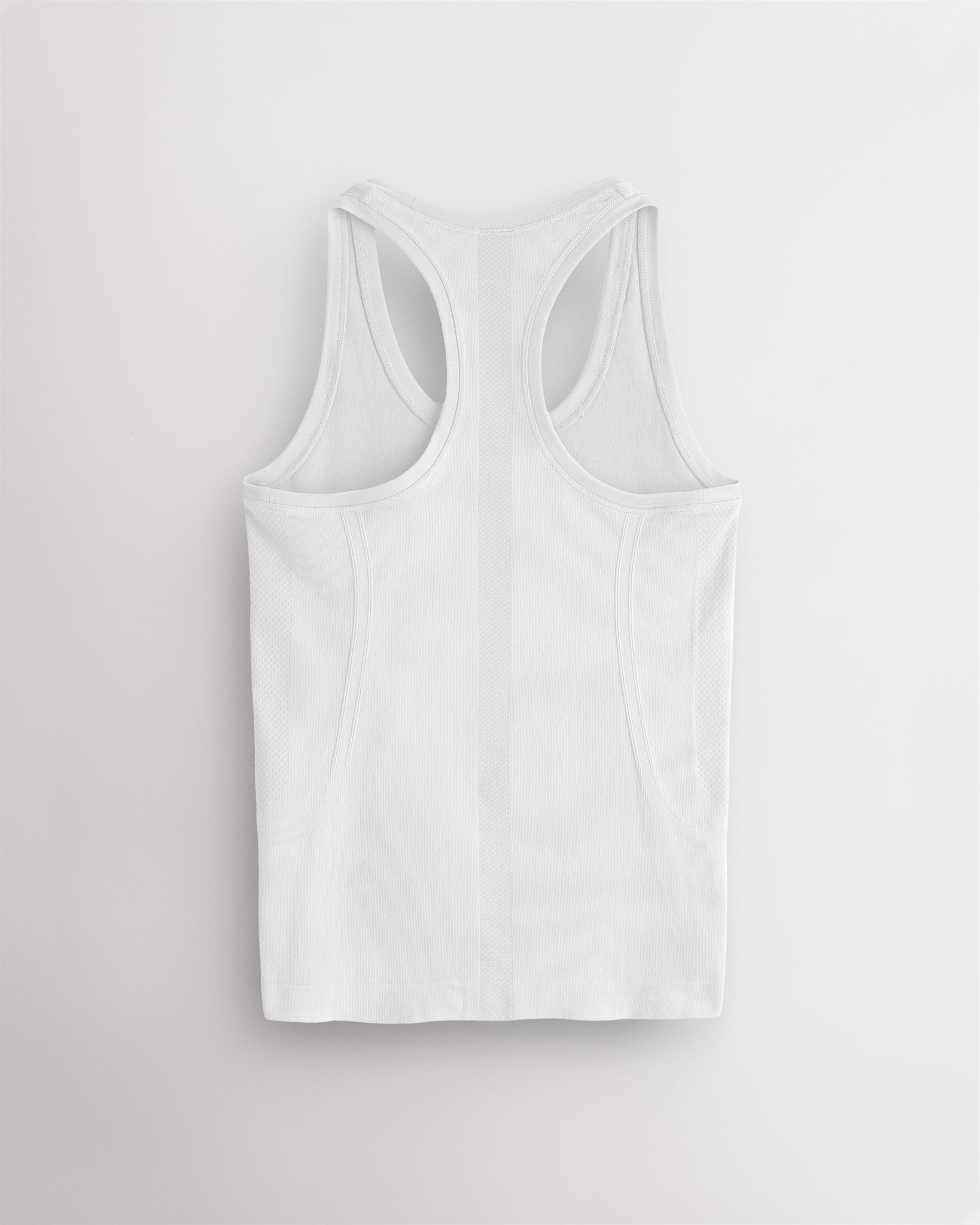 Back view of the white Stelle seamless tank top, laid flat to show the racerback straps.