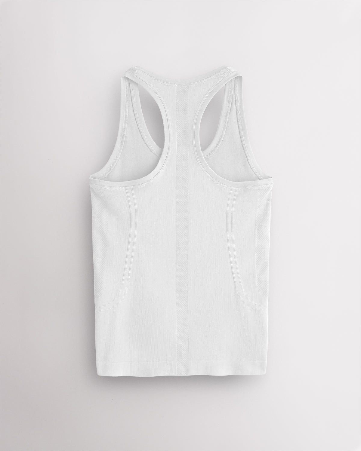 Back view of the white Stelle seamless tank top, laid flat to show the racerback straps.