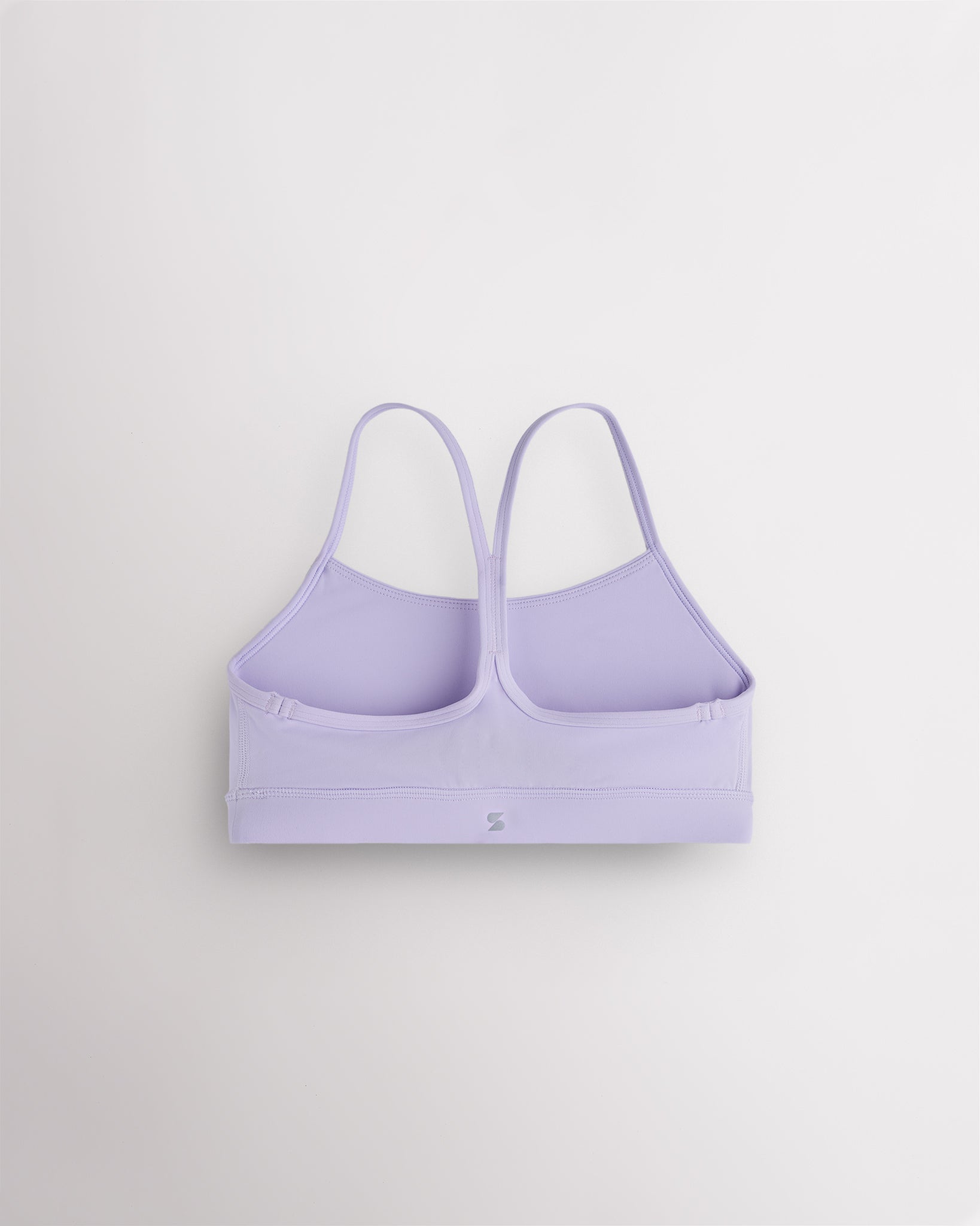Back view of lavender girls sports bra showing minimal Y-shaped straps, smooth seams, and supportive band.