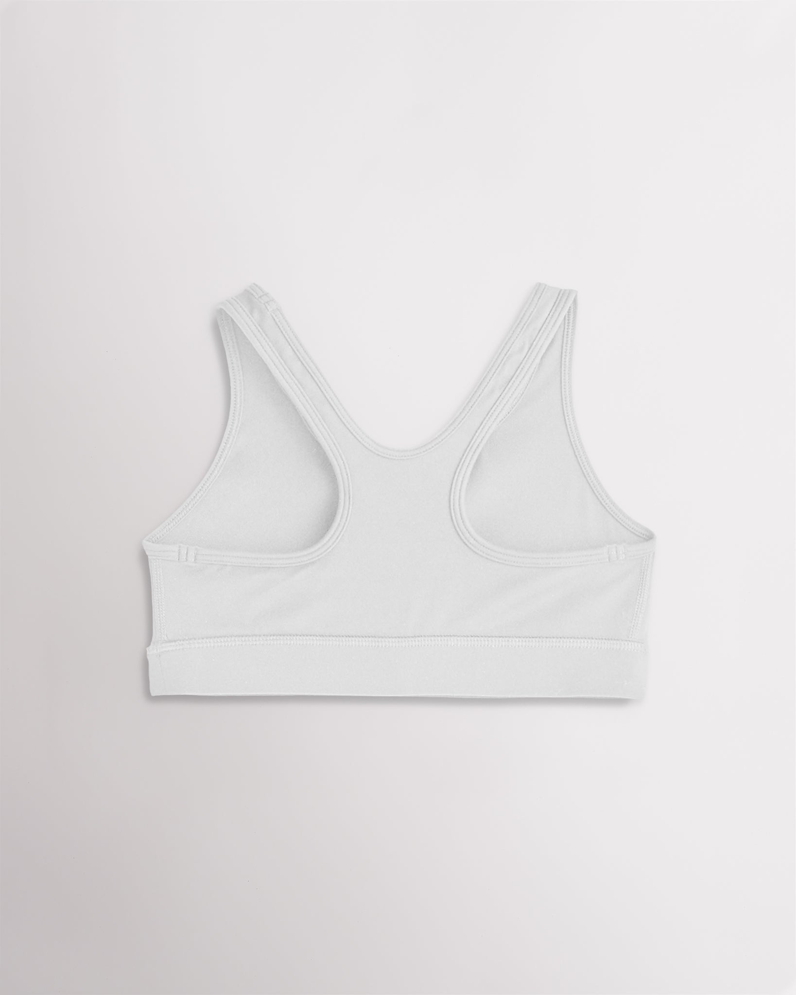 White racerback sports bra for girls with wide straps and a smooth band.