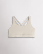 Girls creme sports bra with a scoop neckline, supportive band, and strappy criss-cross back design.