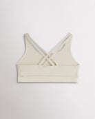 Back view of a girls creme sports bra featuring multiple criss-cross straps and a wide supportive band.