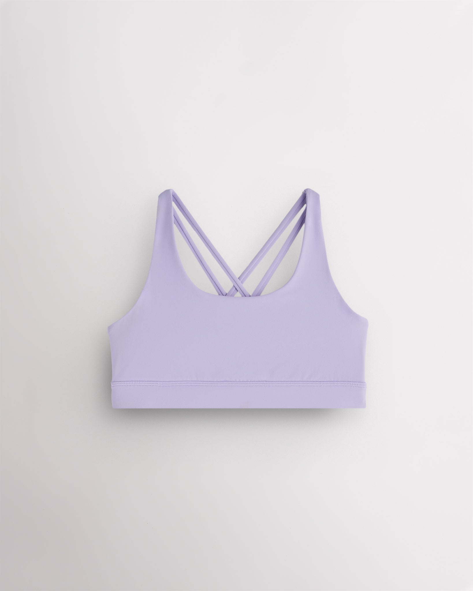 Girls lavender sports bra with a scoop neckline, supportive band, and strappy criss-cross back design.