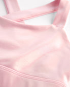 Close-up of pink metallic girls tank top showing iridescent shimmer fabric and smooth seam detail.