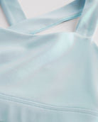 Close-up of light blue metallic girls tank top showing iridescent shimmer fabric and smooth seam detail.