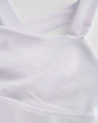 Close-up of white metallic girls tank top showing iridescent shimmer fabric and smooth seam detail.