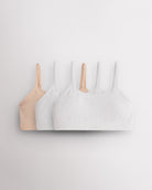 Three Stelle girls seamless cami bras in Soft Butter and white with slim adjustable straps and soft ribbed bands.