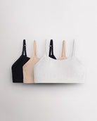 Three Stelle girls seamless cami bras in black, Soft Butter and white with slim adjustable straps and soft ribbed bands.