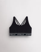 Black Stelle girls sports bra laid flat, showing the scoop neck and logo underband.