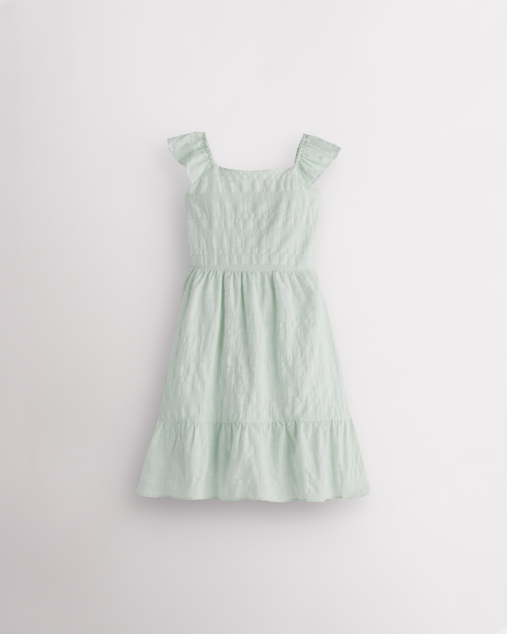 Girls pastel green flutter sleeve sundress with square neckline, smocked waist, and tiered hem, lightweight summer dress front view