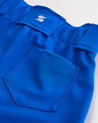 Close-up of girls blue softball pants showing the back pocket and waistband detail.