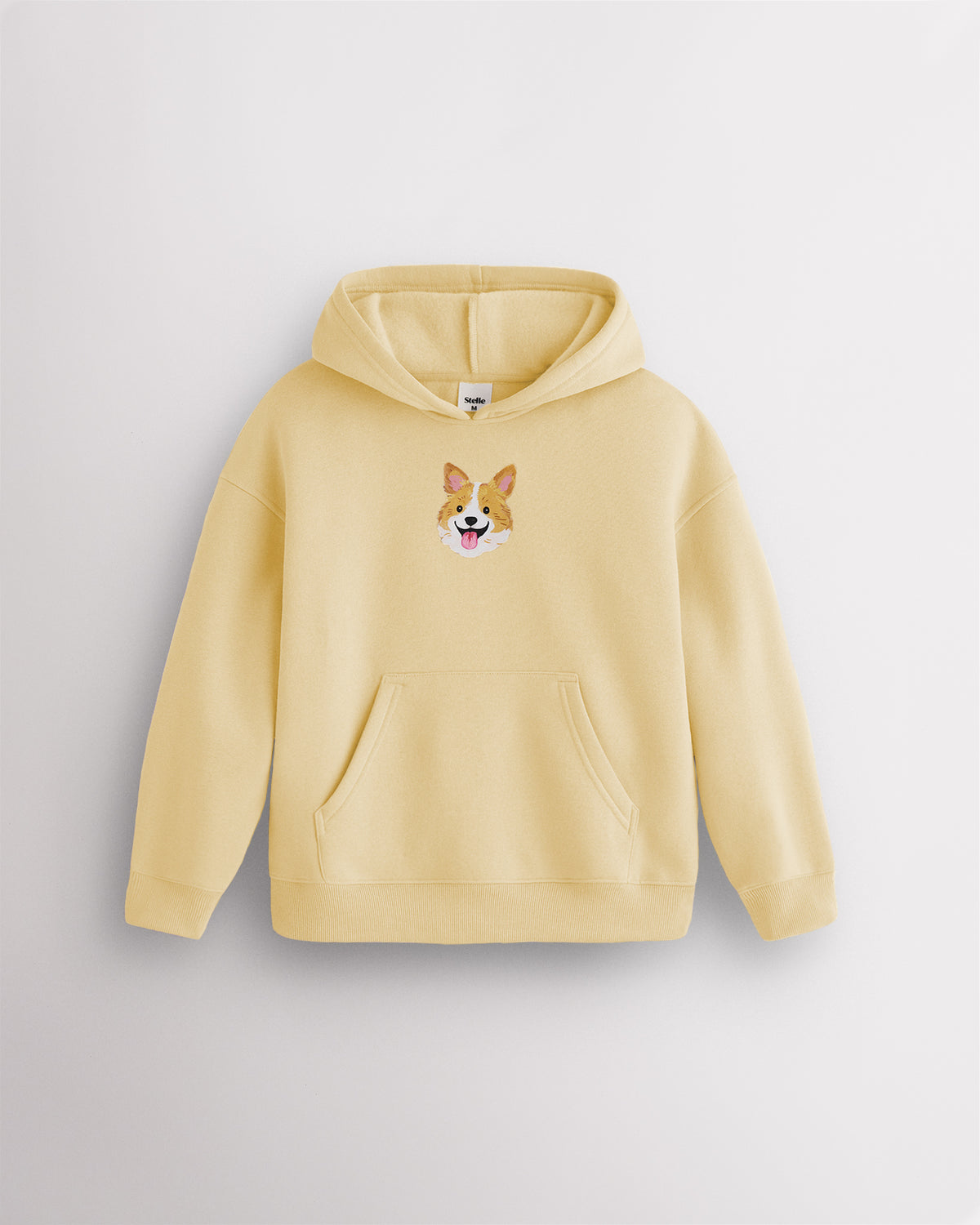 Butter kids dog print hoodie laid flat with hood, front kangaroo pocket, ribbed cuffs and hem, and corgi graphic.