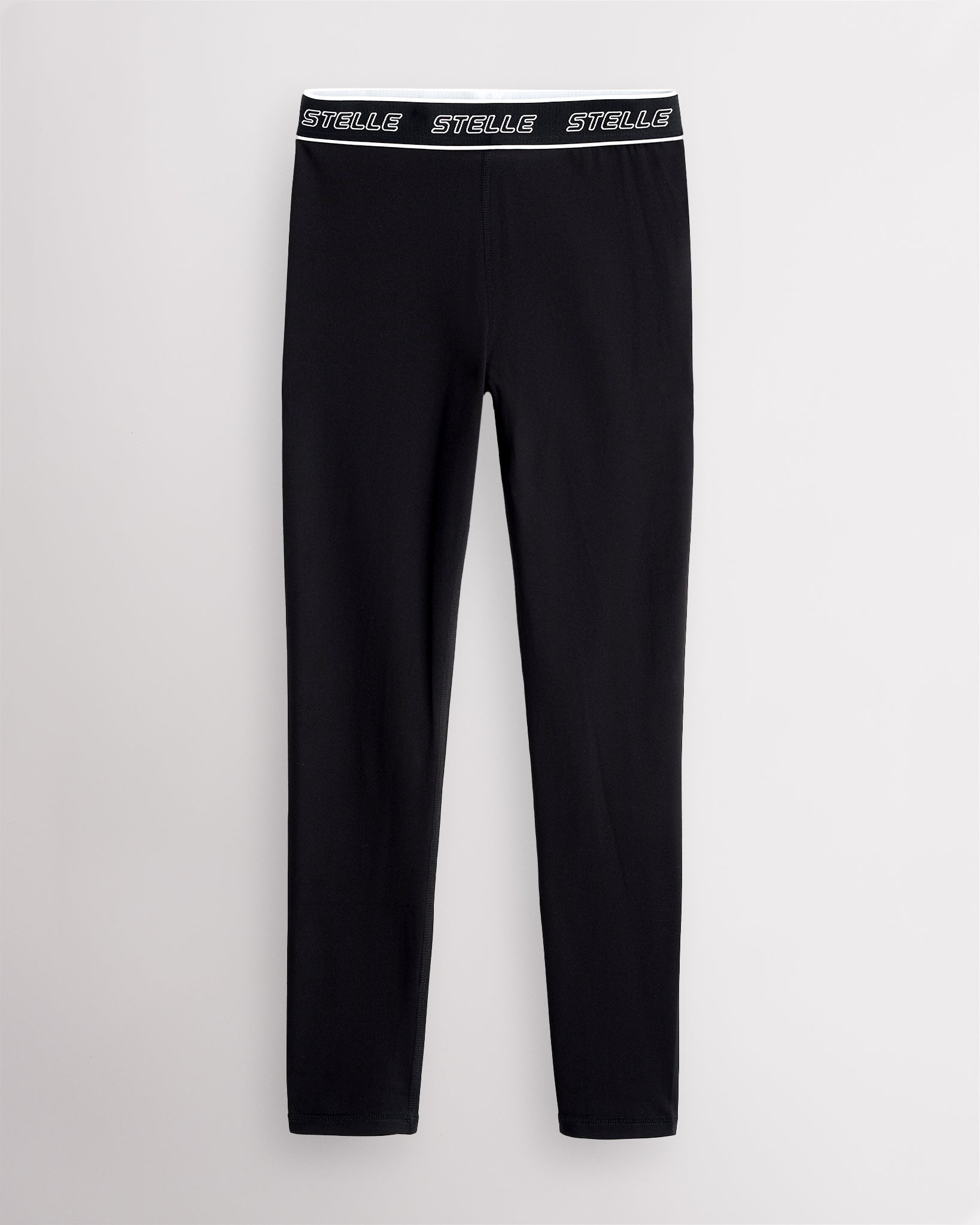 Black Stelle girls leggings laid flat, showing the full-length cut and logo waistband.