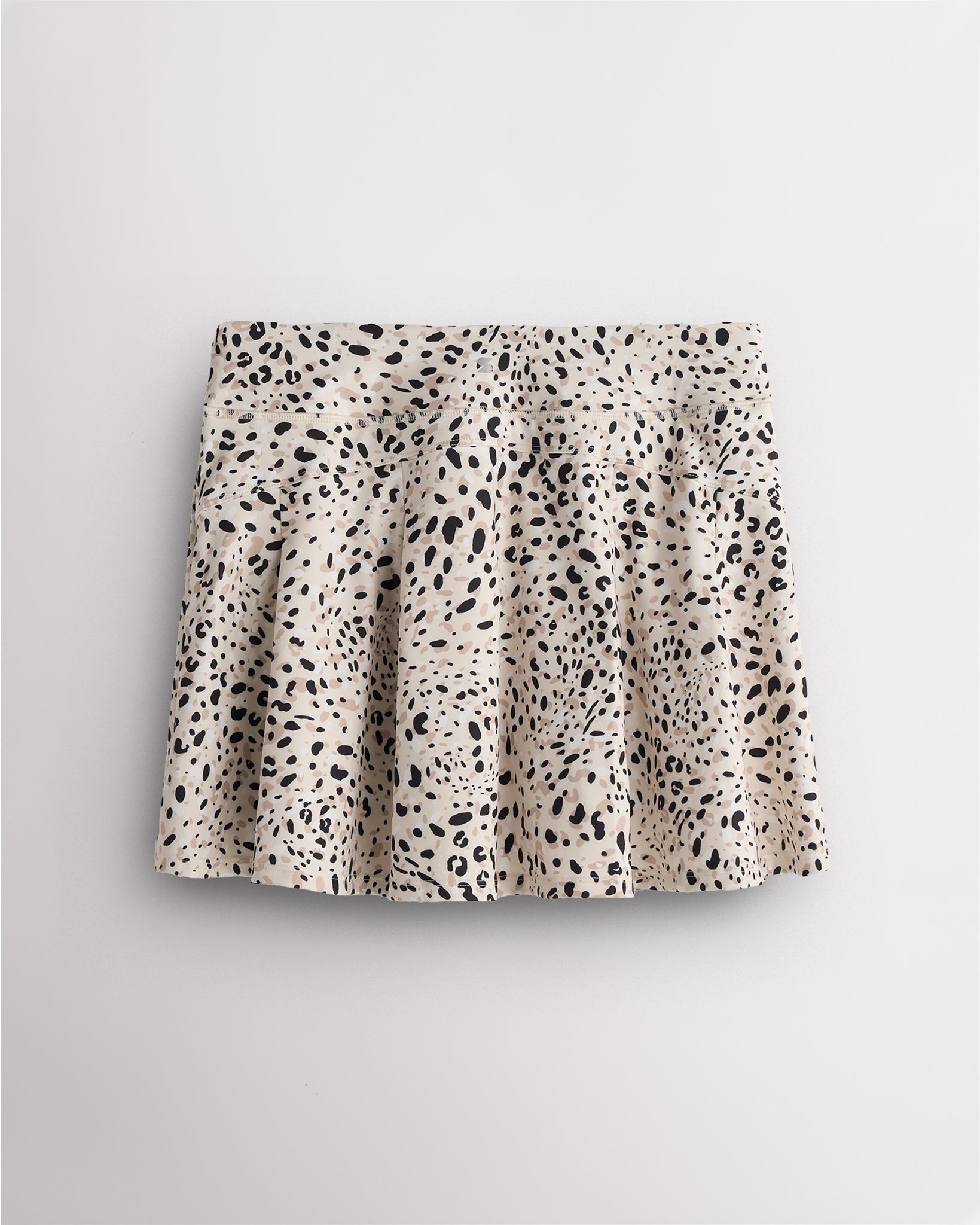 Back view of pleated tennis skirt in white cheetah showing flared silhouette