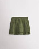 A quick-dry army green tennis skirt with a smooth front, ruffle back hem, and built-in shorts with pockets for comfortable coverage on and off the court.