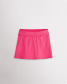 A quick-dry dreamhouse pink tennis skirt with a smooth front, ruffle back hem, and built-in shorts with pockets for comfortable coverage on and off the court.