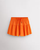 Orange Kids Let’s Bounce Shorts with flowy design, elastic waistband, drawstring, lightweight fabric, and built-in lining for practice and play.