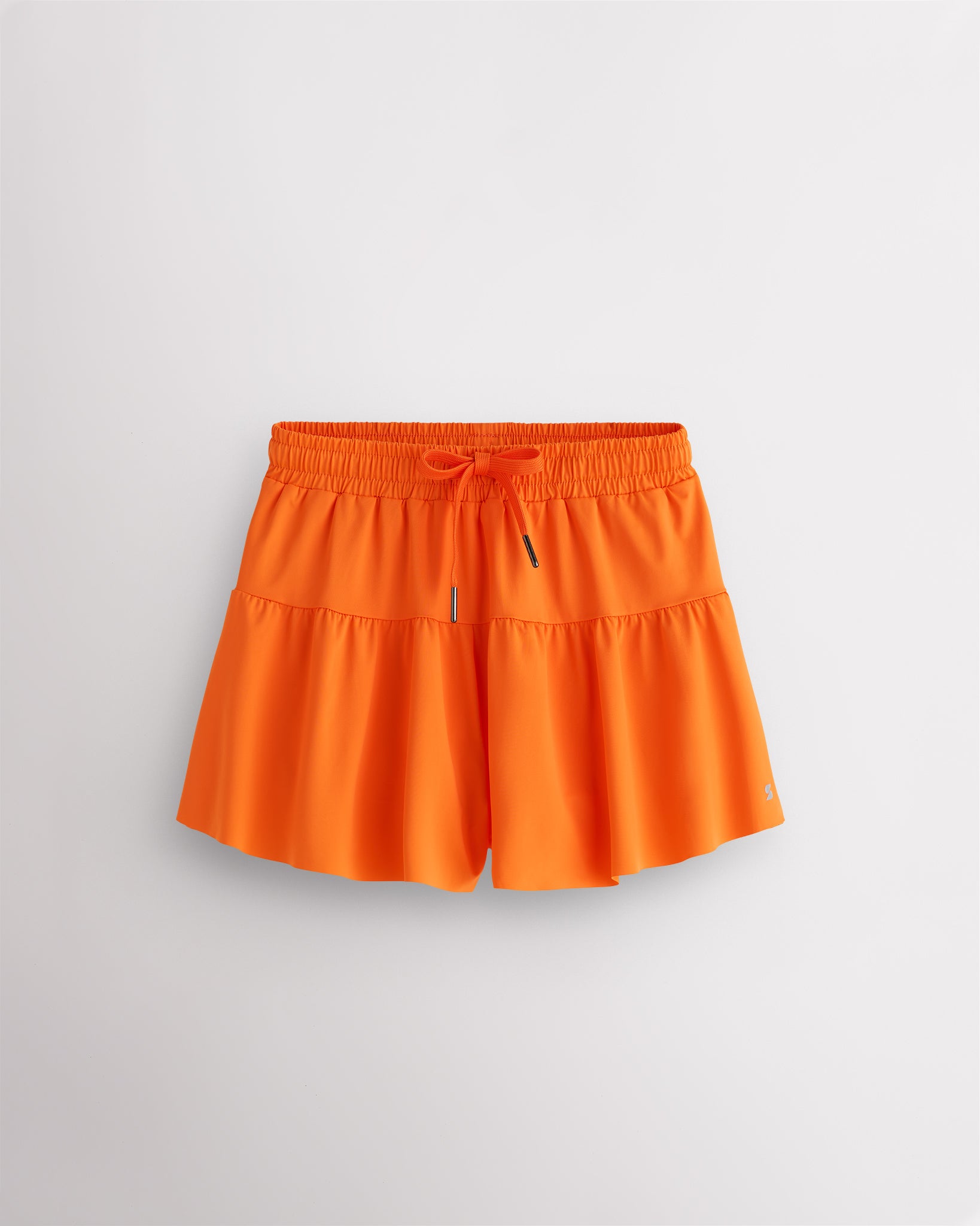 Orange Kids Let’s Bounce Shorts with flowy design, elastic waistband, drawstring, lightweight fabric, and built-in lining for practice and play.