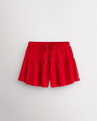 Red Kids Let’s Bounce Shorts with flowy design, elastic waistband, drawstring, lightweight fabric, and built-in lining for practice and play.