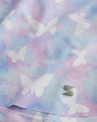 Close-up of Magic Flutter flowy shorts showing soft printed fabric, hem detail, and small Stelle logo.