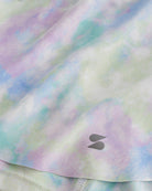 Close-up of Spring Mist flowy shorts showing soft printed fabric, hem detail, and small Stelle logo.