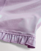 Close-up of lavender shimmer active shorts showing iridescent fabric and ruffle hem detail