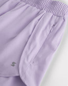 Close-up of lavender girls running shorts showing zipper side pocket, curved hem, and smooth fabric for sports and everyday wear.