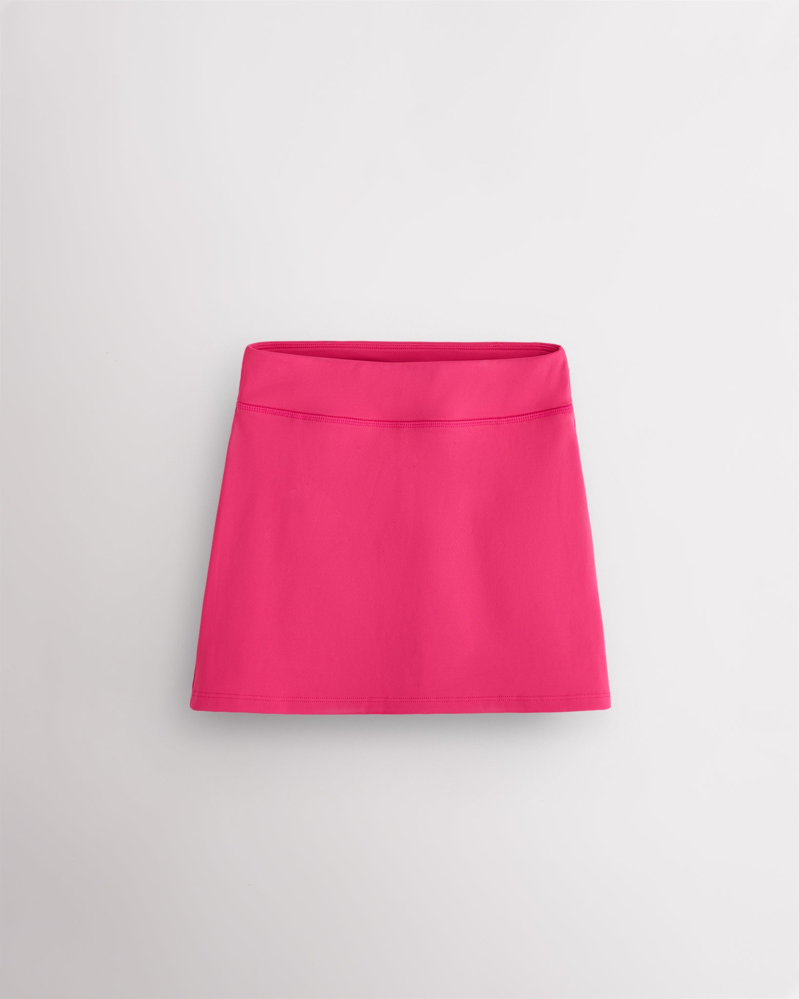 Dreamhouse pink girls ruffle tennis skirt with elastic waistband, built-in shorts, and smooth stretch fabric.