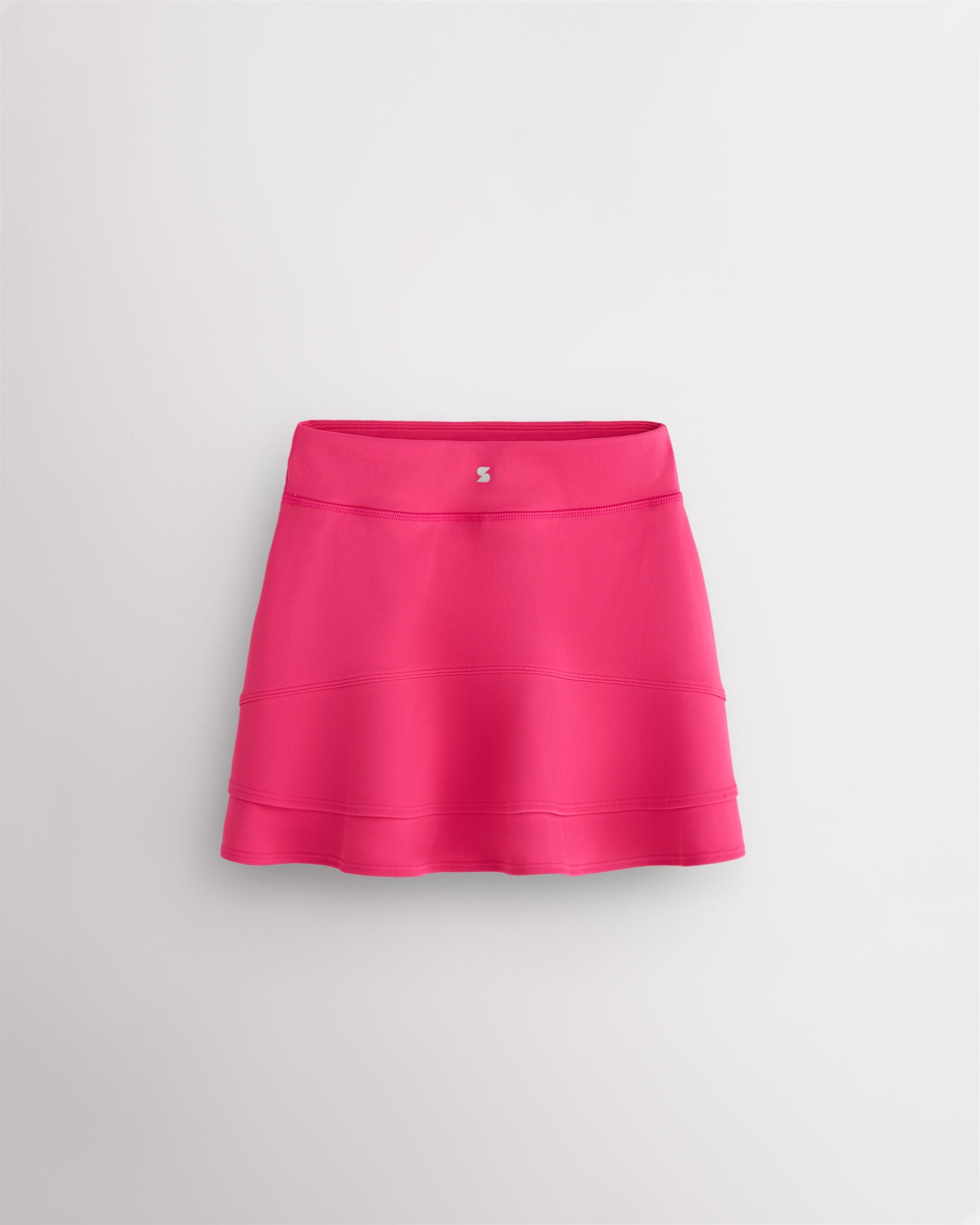 Back view of dreamhouse pink girls ruffle tennis skirt showing layered ruffle detail, elastic waistband, and Stelle logo.
